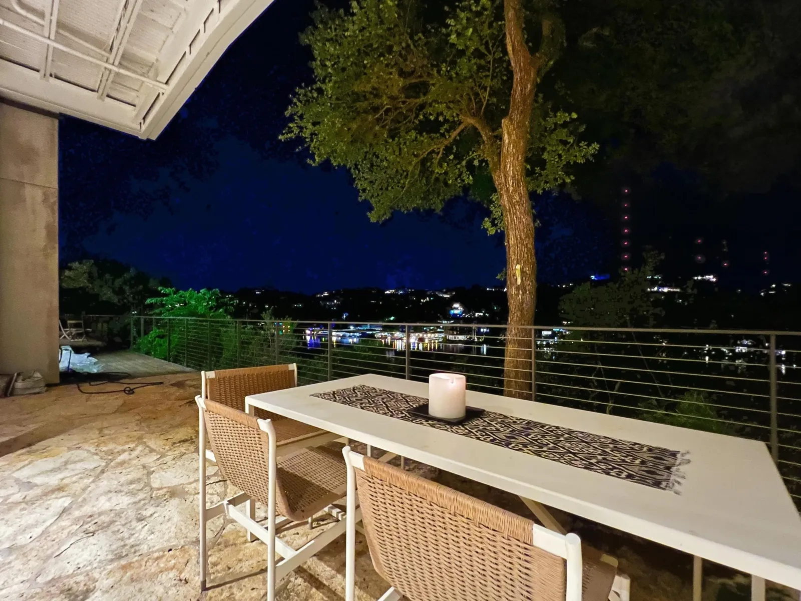 Covered patio at night with the city lights beyond